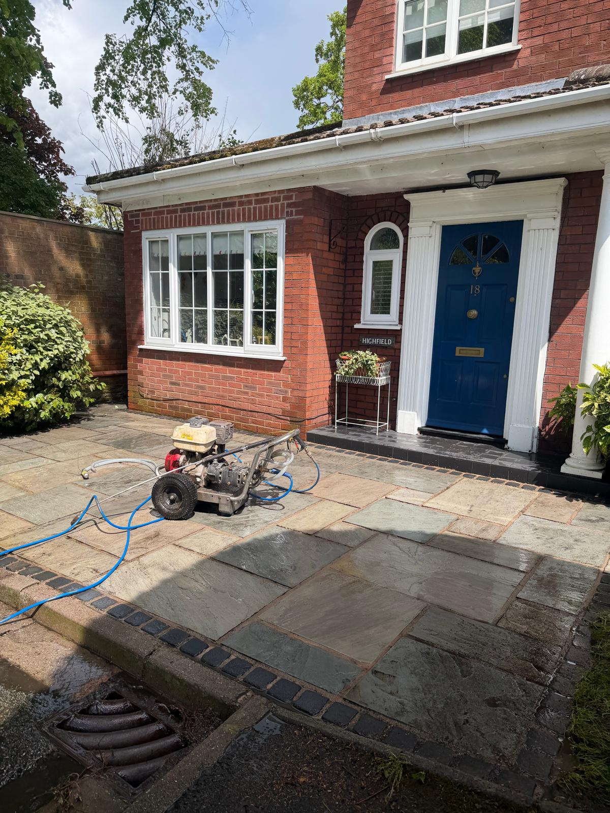 Indian stone driveway after pressure washing - slabs restored to original colour with equipment on site