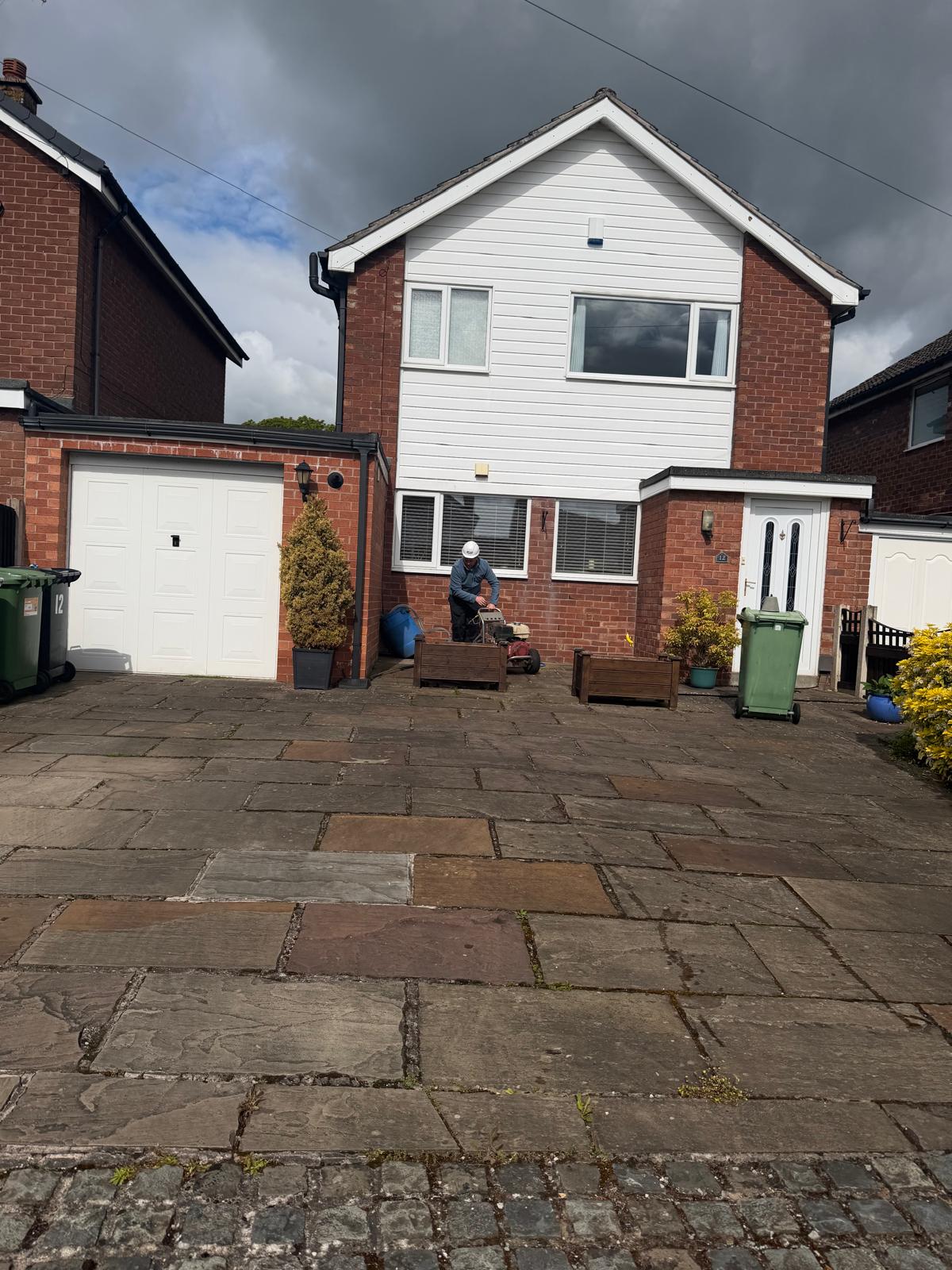 Flagstone driveway before cleaning - dark staining and moss covering natural stone
