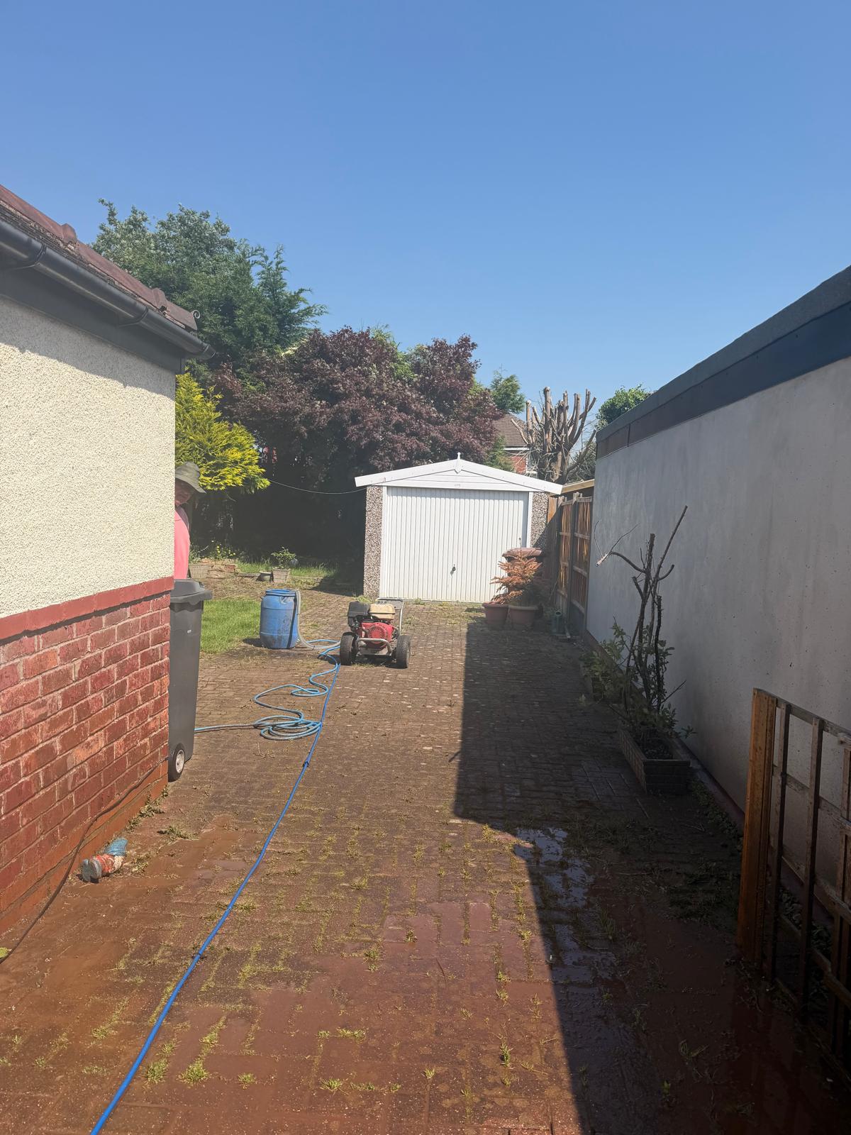 Block paving side passage before cleaning - moss and weeds growing between joints