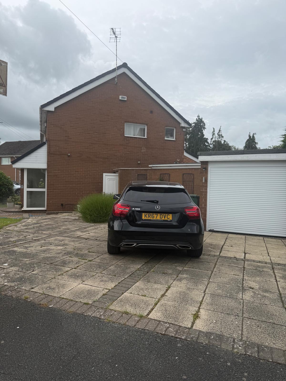 Slab driveway before cleaning - dirty and discoloured paving slabs with car parked