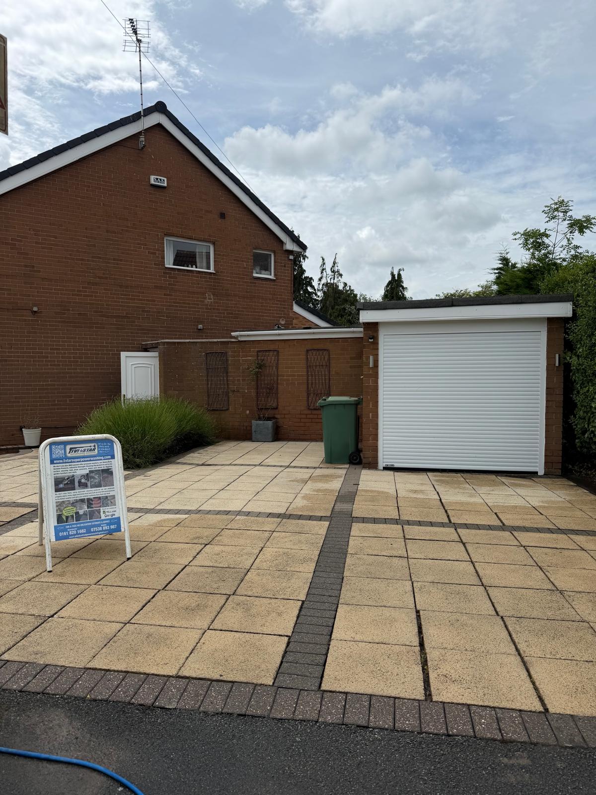 Slab driveway after pressure washing - clean paving slabs with company sign