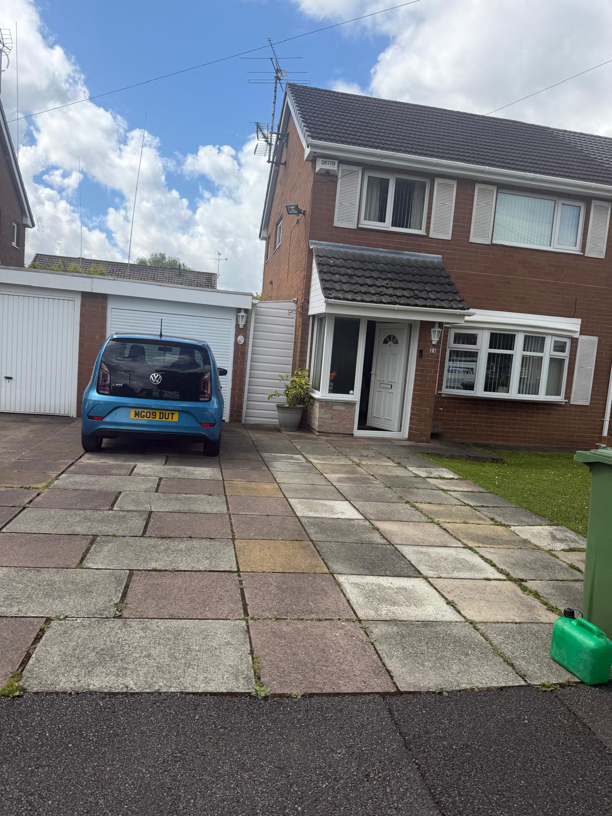 Flagstone driveway before cleaning - mossy and weathered slabs with weeds