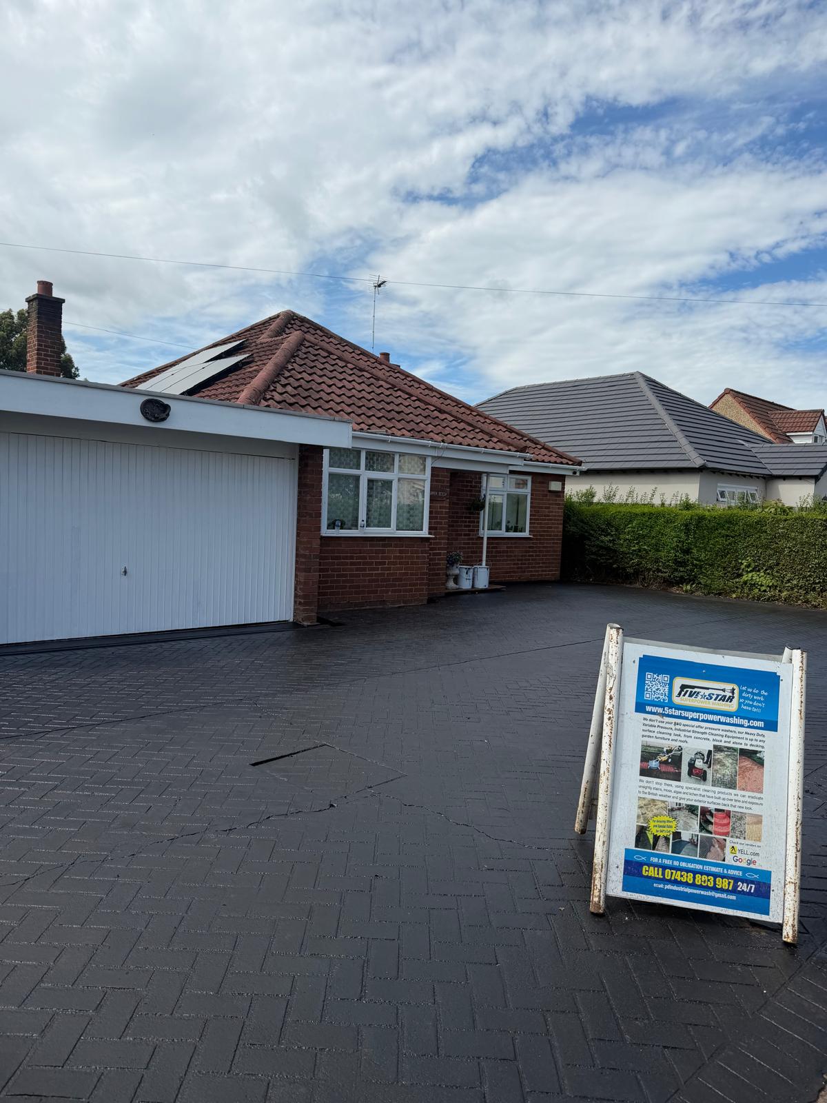 Block paving driveway after sealing - fresh dark seal coat with company sign